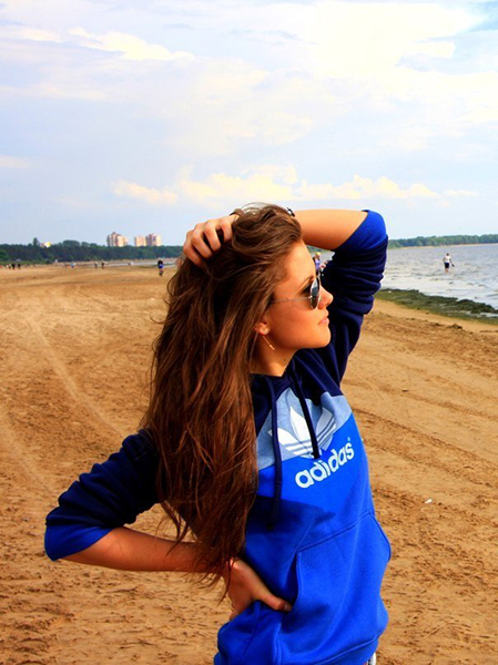 Девушка в куртке адидас на пляже