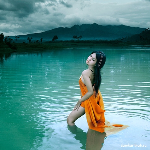 азиатка девушка купается в реке, стоит в воде и купается в озере